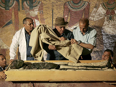 Der Chef der gyptischen Altertmerverwaltung, Zahi Hawass entfernt die schtzende Decke ber der Knigsmumie. 